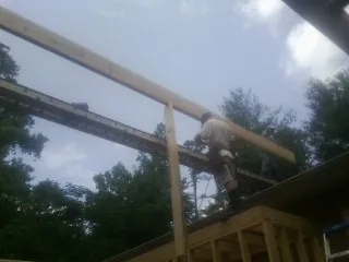 Carpenter setting a ridge beam over a new addition frame — Ice Dam Removal by Roofing Brothers in Pardeeville