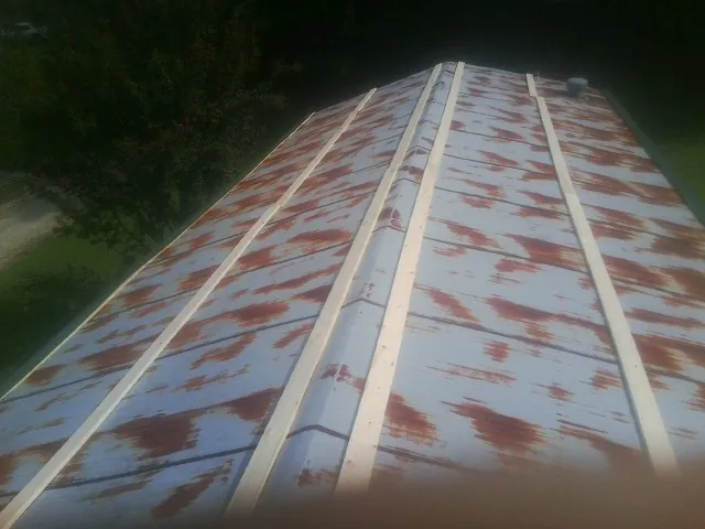 Rusted metal roof panels with new wood purlins before replacement — Storm Damage Roof Repair in Pardeeville by Roofing Brothers