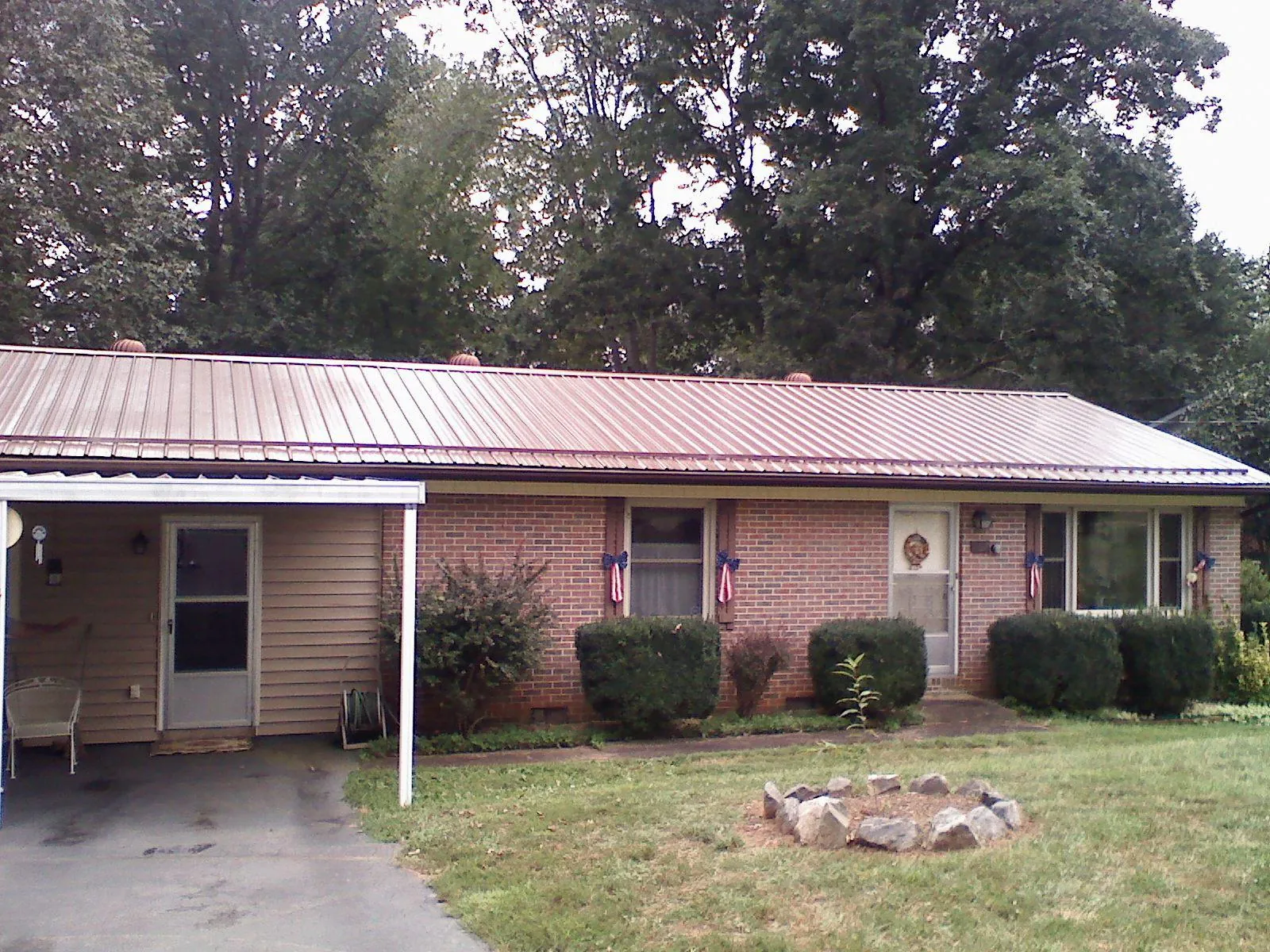 Bronze metal roof and carport on a brick ranch home — Roof Repair work by our crew in Pardeeville
